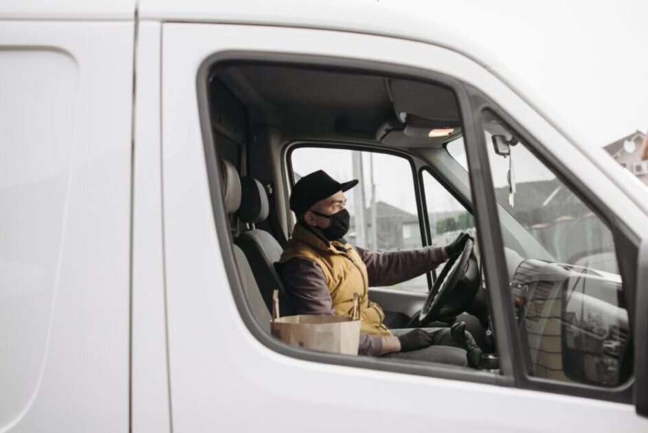 man in yellow vest driving a van
